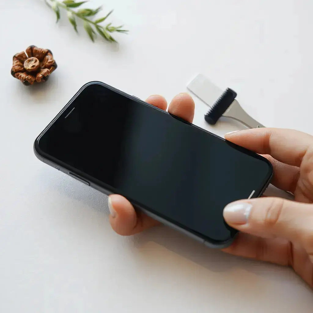 Smartphone with a subtle textured screen protector surface, shown with tools for smooth, bubble-free installation